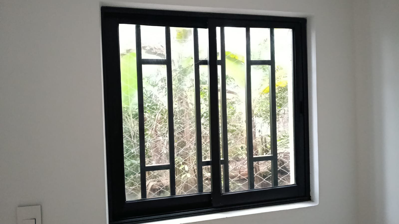 Ventana negra con reja de seguridad instalada