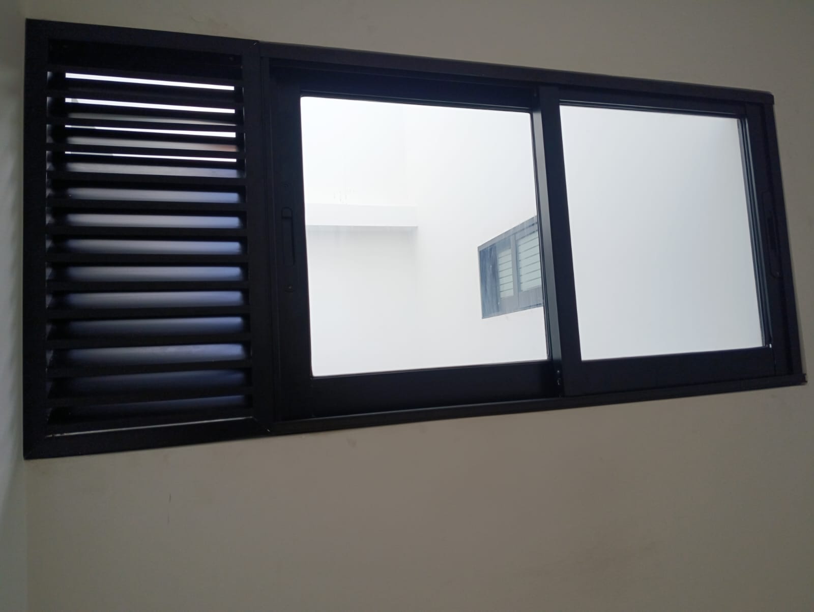 Ventana negra con persiana fija y hojas corredizas instalada en Medellín
