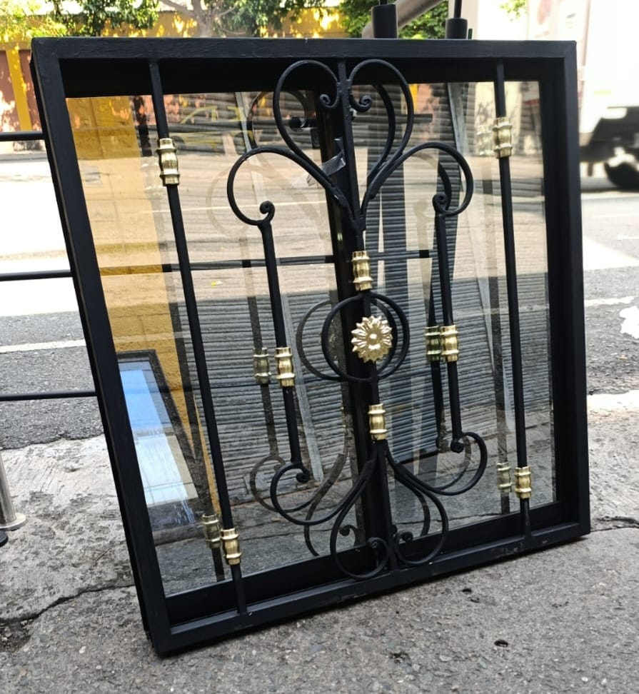 Ventana pequeña con forja ornamental y detalles dorados