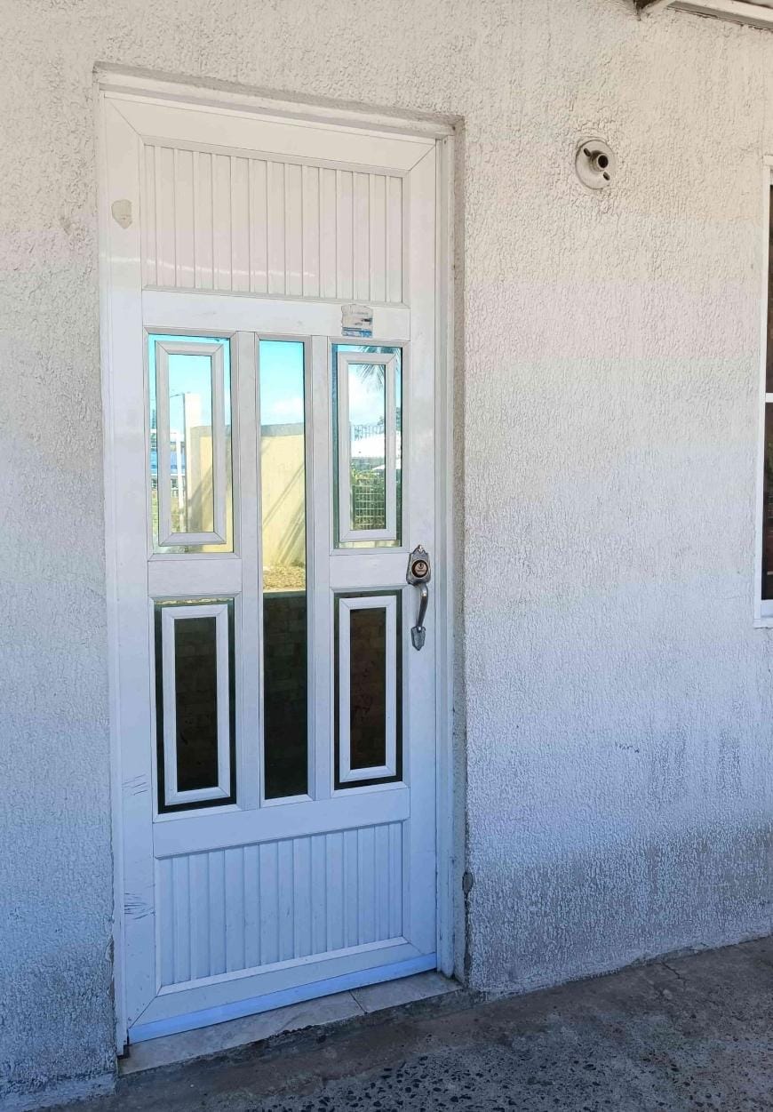 Puerta blanca de aluminio con vidrios instalada en Medellín