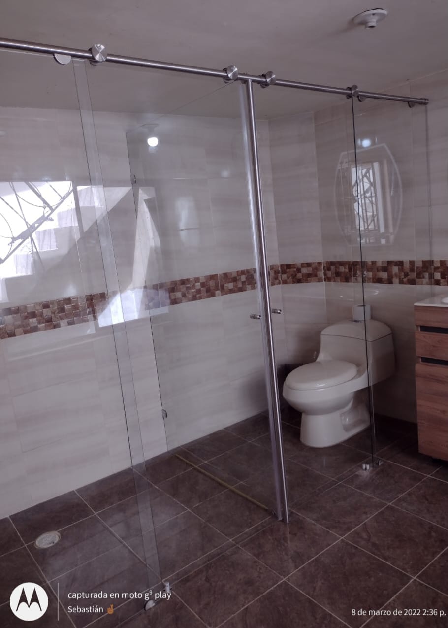 Cabina de ducha en vidrio templado con riel de acero inoxidable en Medellín