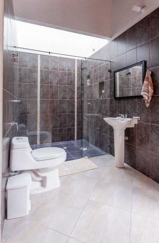 División fija de vidrio templado en baño gris