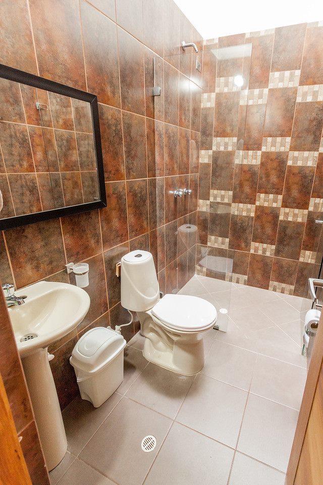División fija de vidrio templado en baño terracota